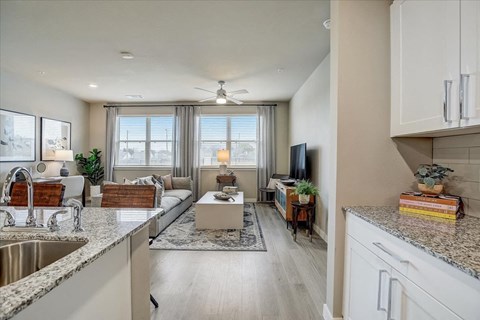 a kitchen and living room with a couch and a tv